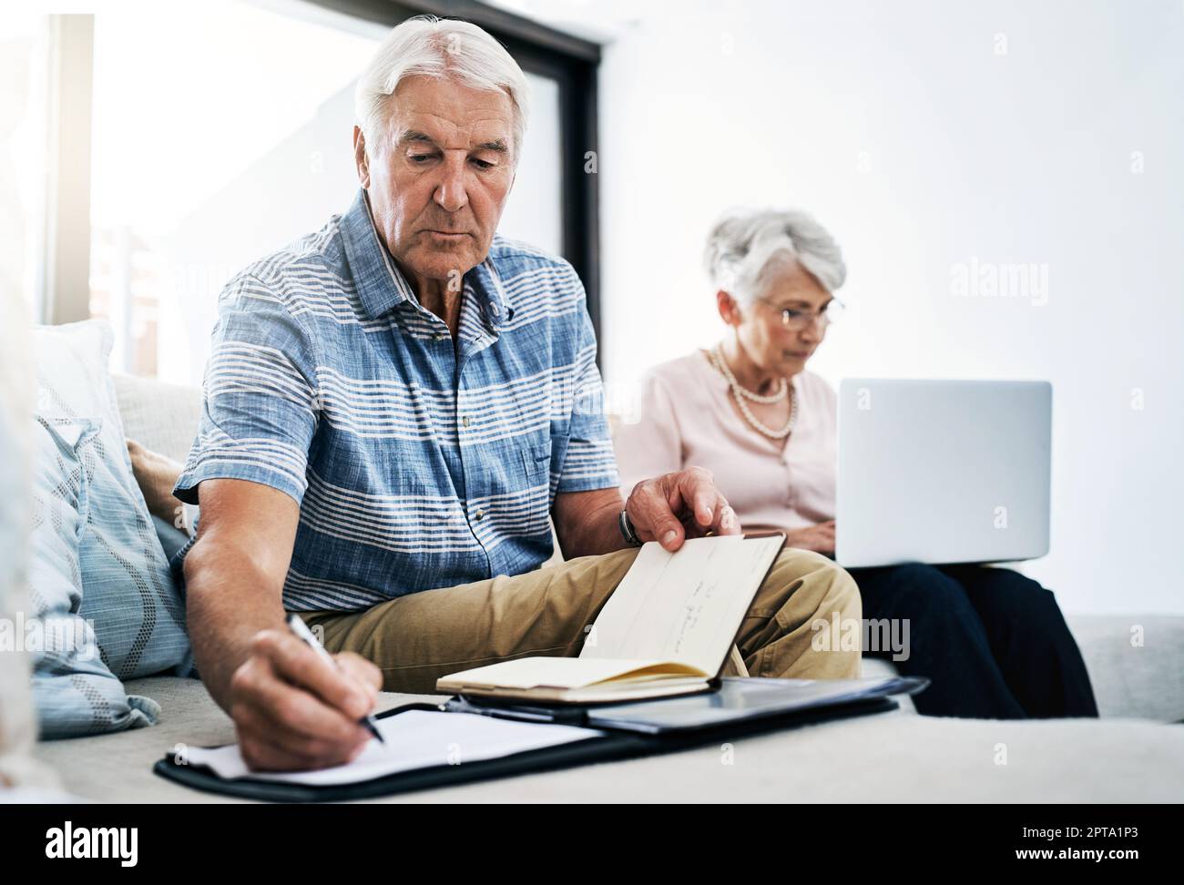 The cost of living is serious business. a senior couple going through their paperwork together at home. Stock Photo
