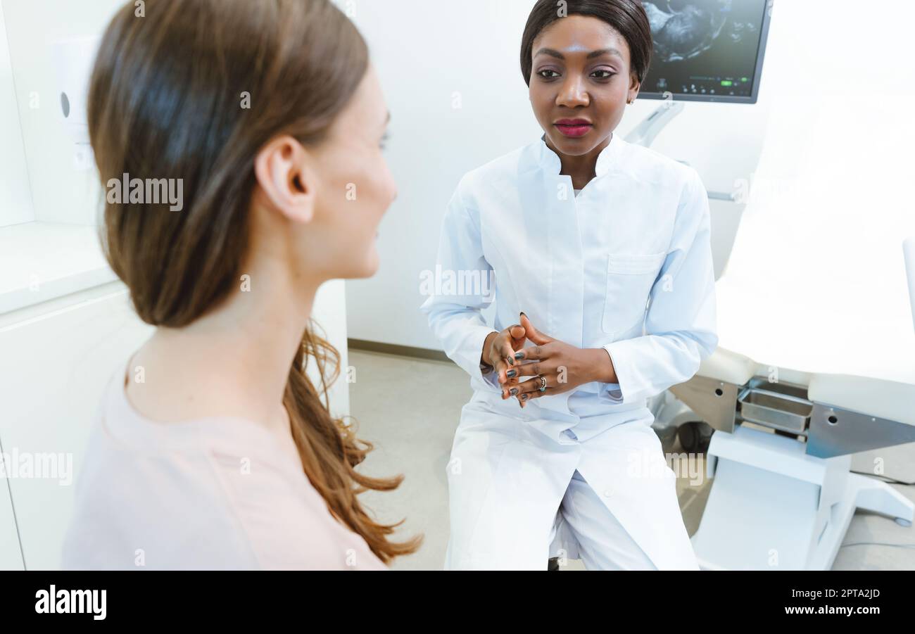 Black gynecologist showing woman early ultrasounds of her pregnancy Stock Photo Alamy