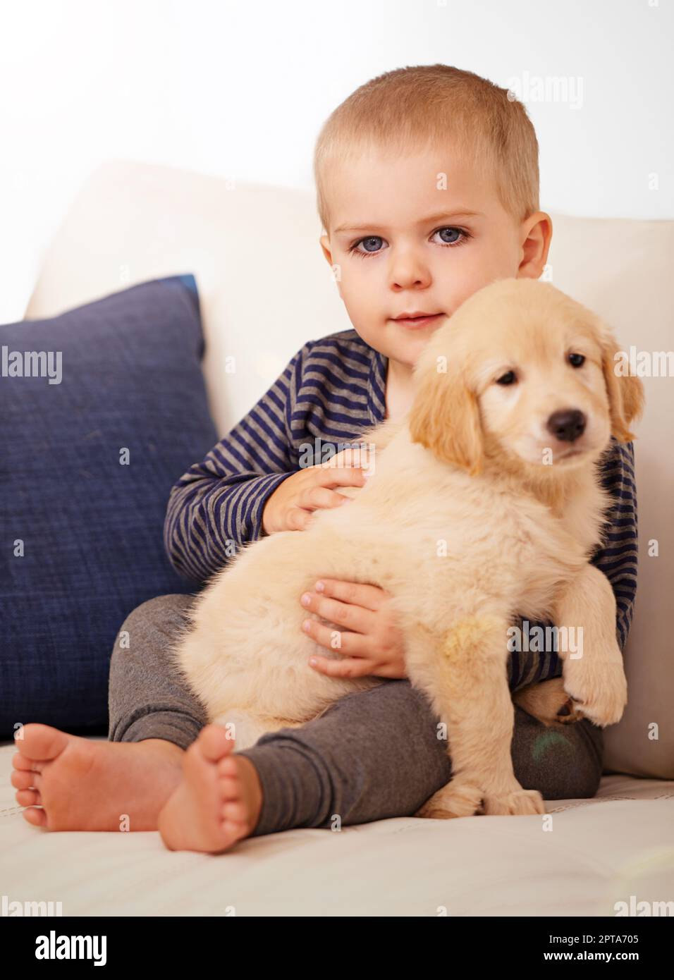 Snuggling his way into his heart. An adorable little boy with his puppy