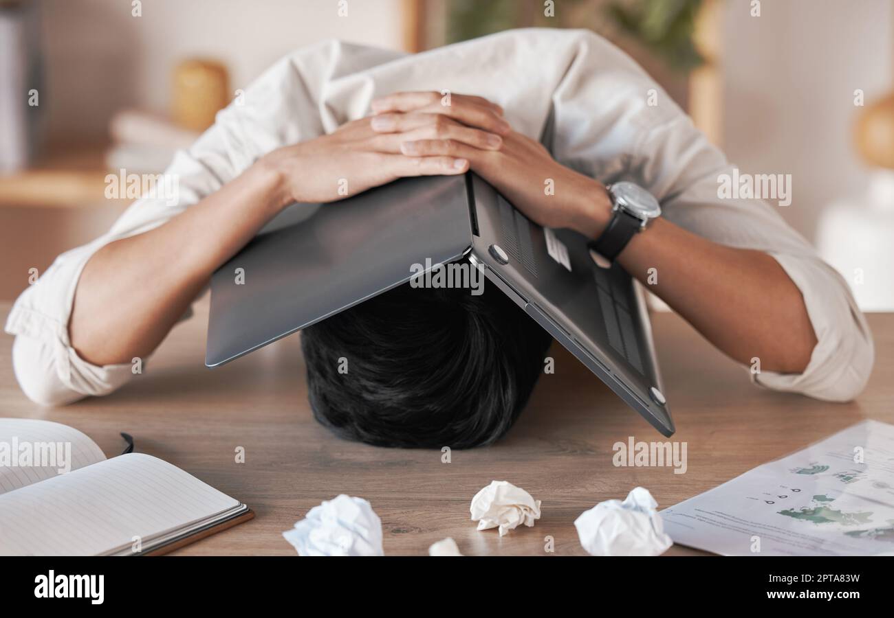 Stress, frustrated and burnout for man with laptop to cover face, head or skull overwhelmed with paperwork. Marketing business man with crumble paper Stock Photo