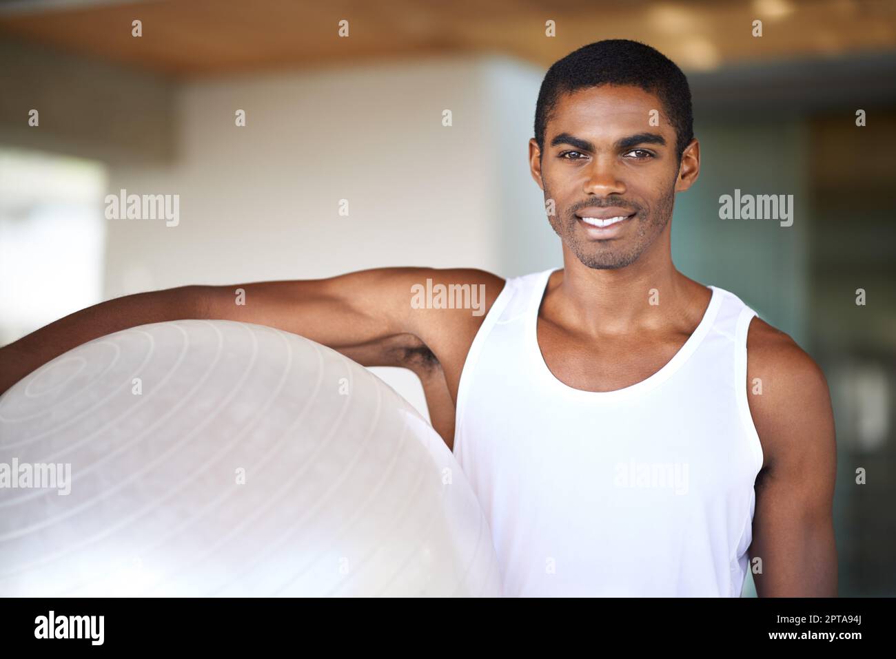 It gives me a full body workout. Portrait of a young man holding a swiss ball Stock Photo Alamy