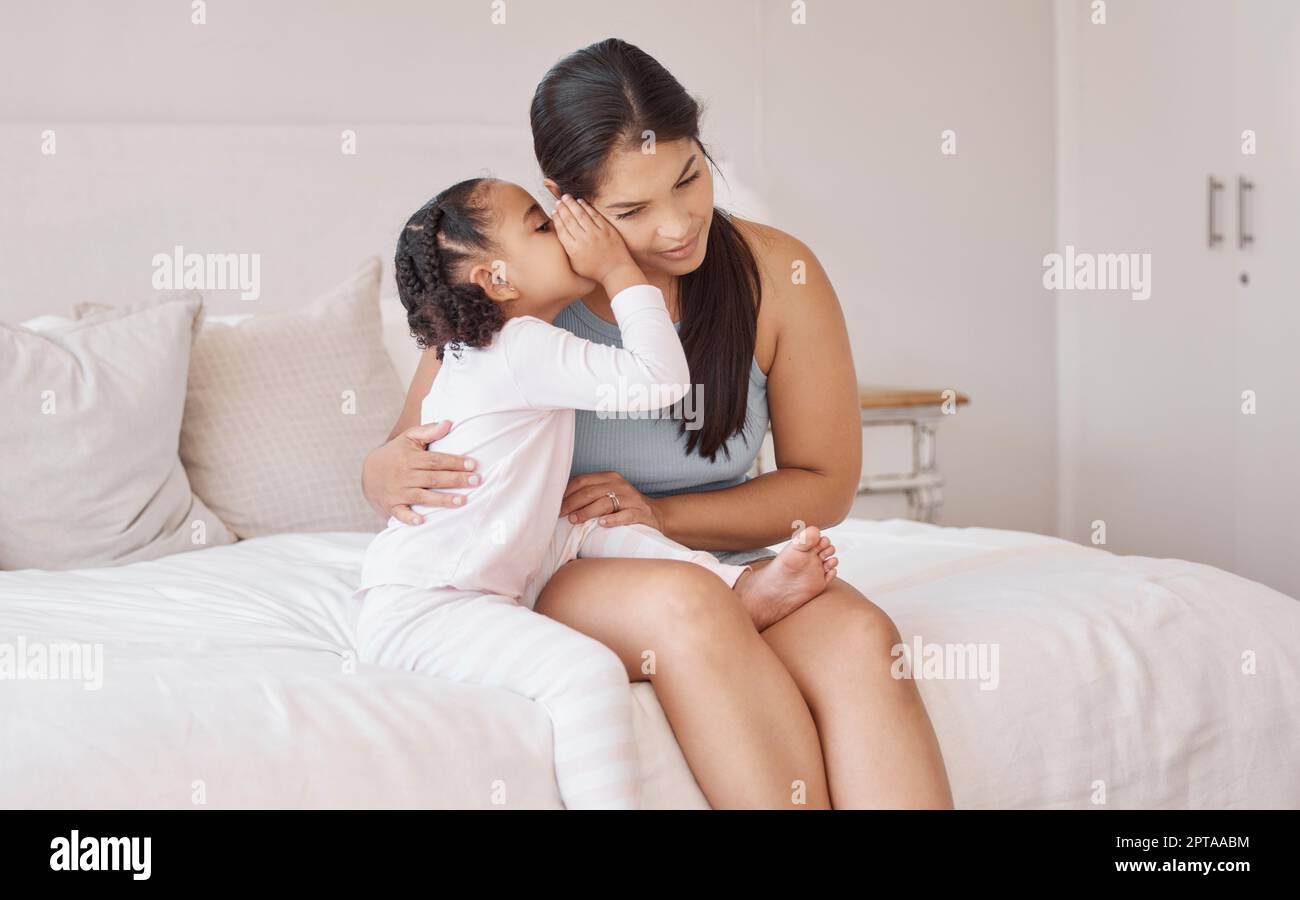 Kids whisper secret in mom ear in home bedroom for trust, love and confidential talk. Care mother listening to young girl child tell privacy story, go Stock Photo