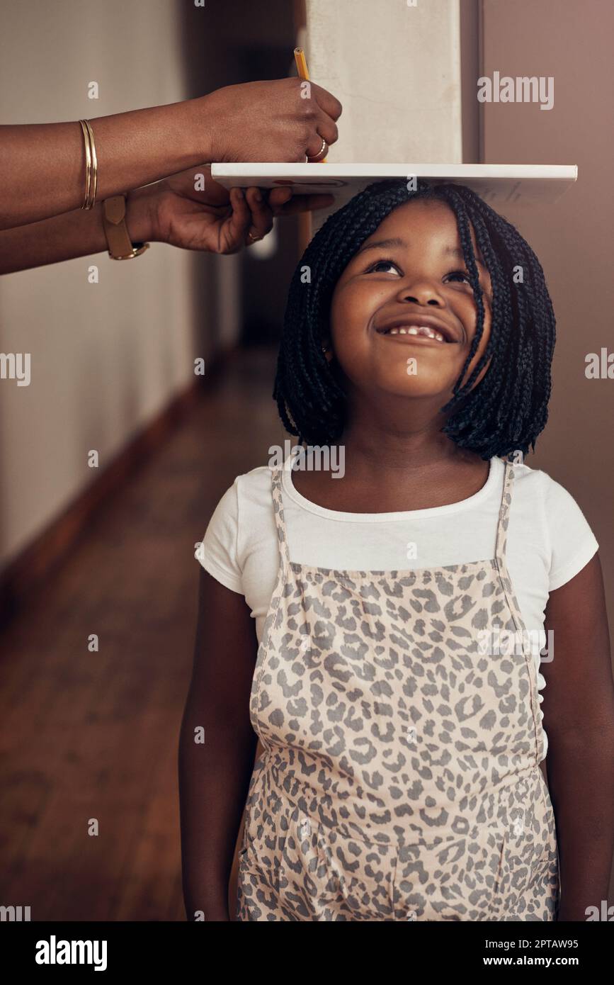 They grow up way too fast. a mother measuring the height of her