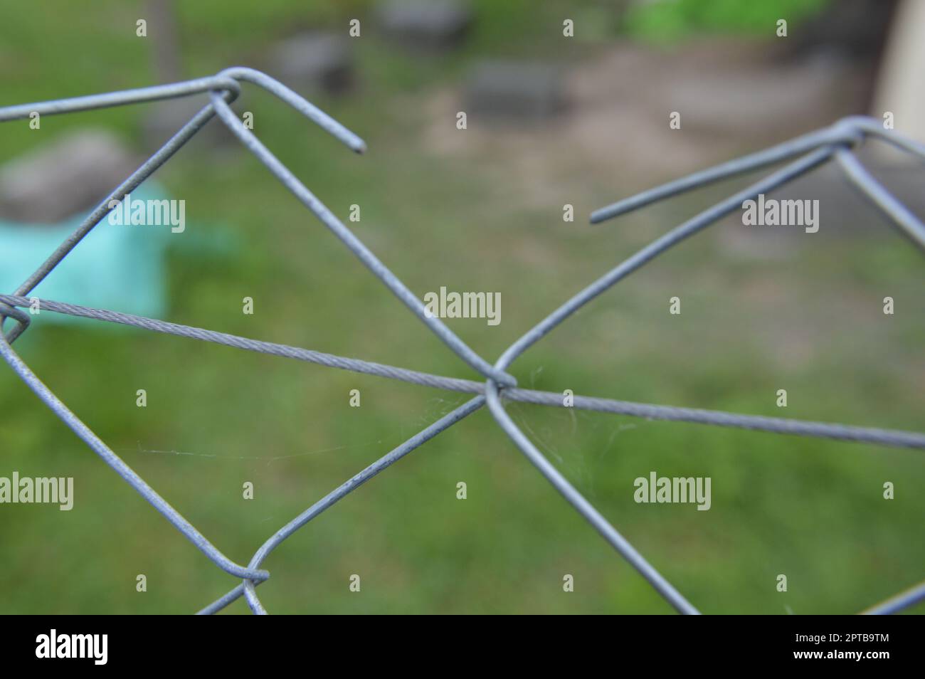 Tensioning and securing a mesh fence with a the metal wire netting Stock Photo Alamy