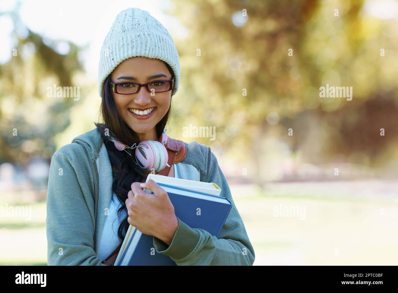 On the way to class. a young college student carrying her school books ...