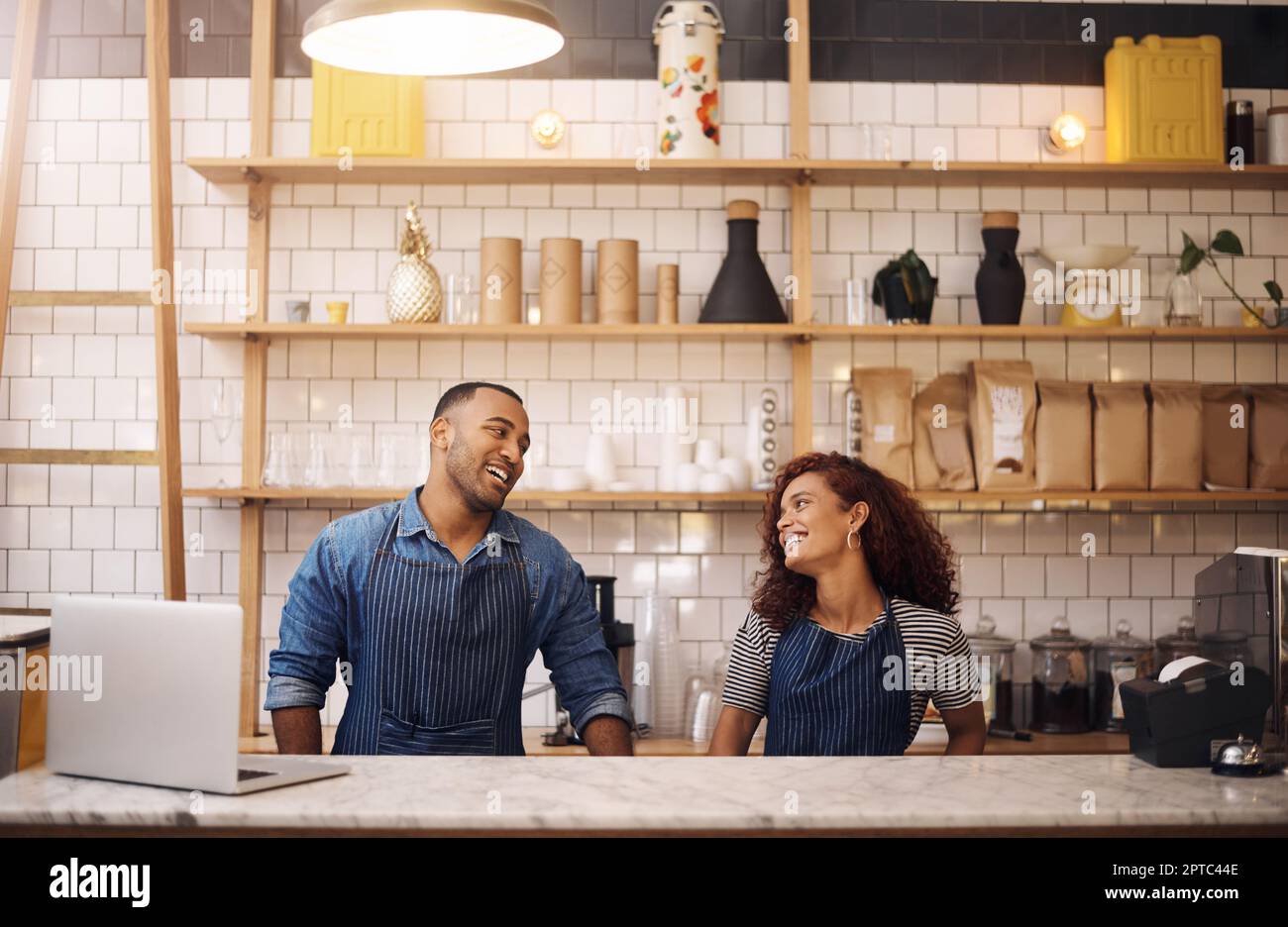 Where would we be without each other. two young business owners standing in their cafe and looking at each other Stock Photo
