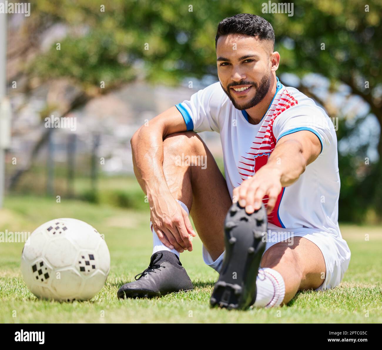 Soccer ball, field and man stretching legs on grass for sport training or  exercise workout. Portrait of young happy athlete, healthy lifestyle  motivat Stock Photo - Alamy