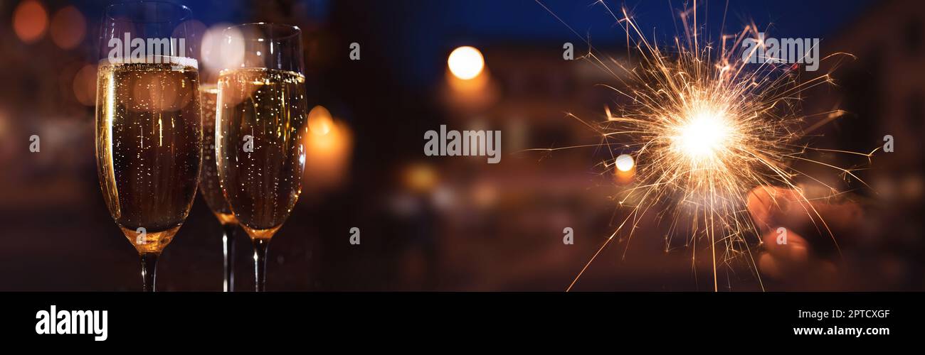 New year's champagne with burning sparkler on new year's night for greetings. Event background for festivals and holidays. Stock Photo