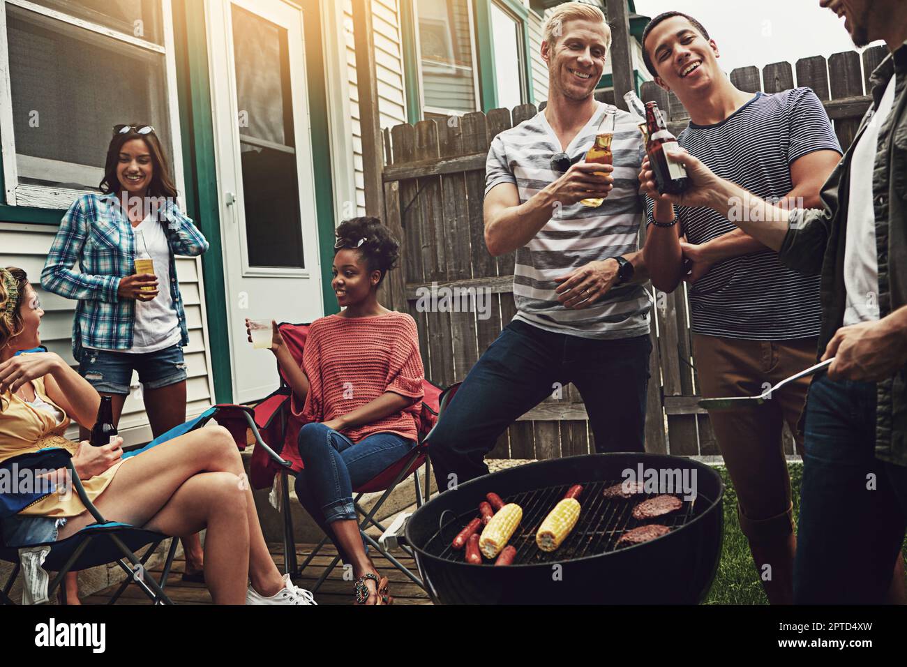 Heres to an awesome cookout. a group of friends having a barbecue in ...