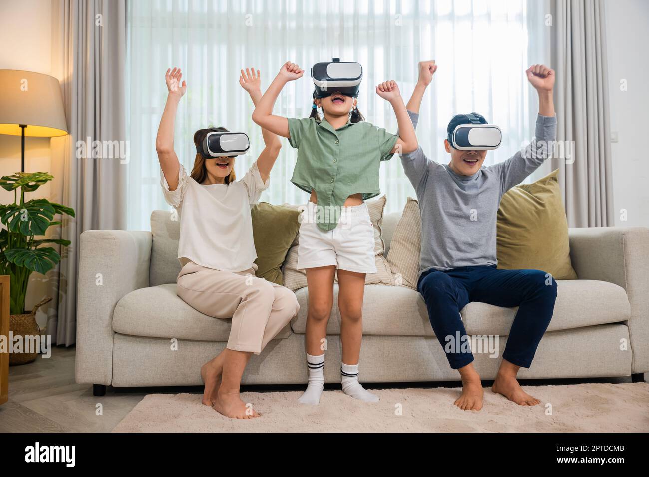 Asian family wear vr glasses headsets sitting on sofa in living room, game  entertainment innovation technology, Happy family have mother father and da  Stock Photo - Alamy