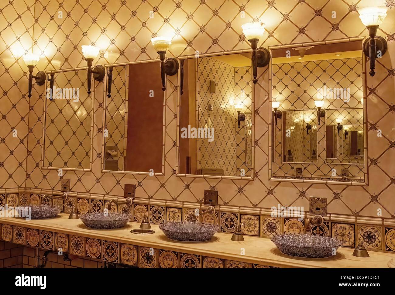 Decorative blue patterned bathroom sinks with mirrors and lights in the