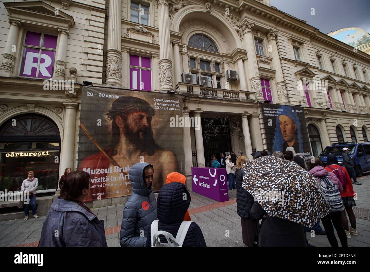 Bucharest, Romania. 27th Apr, 2023: People queue in line in front of Dacia Palace where Art Safari Bucharest and Brukenthal National Museum exhibit the paintings Portrait of a Man with a Blue Chaperon by Jan van Eyck and Ecce Homo by Tiziano Vecelli, the only painting by Titian that Romania owns, stolen in 1968 and recovered after 30 years in 1998. Credit: Lucian Alecu/Alamy Live News Stock Photo