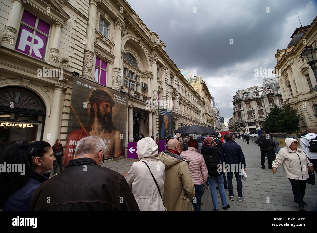 Bucharest, Romania. 27th Apr, 2023: People queue in line in front of Dacia Palace where Art Safari Bucharest and Brukenthal National Museum exhibit the paintings Portrait of a Man with a Blue Chaperon by Jan van Eyck and Ecce Homo by Tiziano Vecelli, the only painting by Titian that Romania owns, stolen in 1968 and recovered after 30 years in 1998. Credit: Lucian Alecu/Alamy Live News Stock Photo