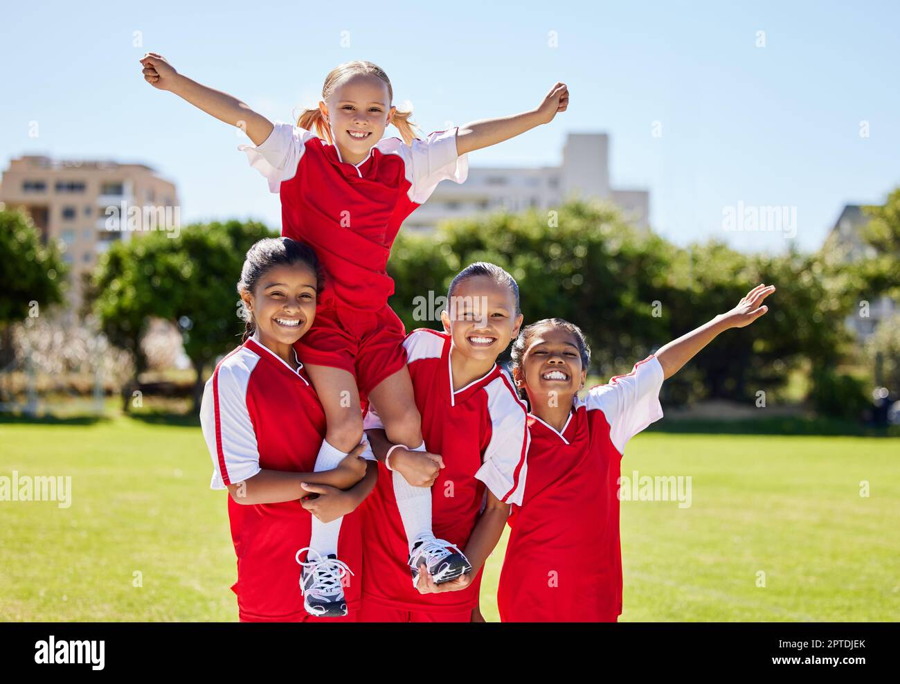 Children, sport and winner by girl soccer player on field team sports victory with little champion group. Fitness, training and football practice by f Stock Photo