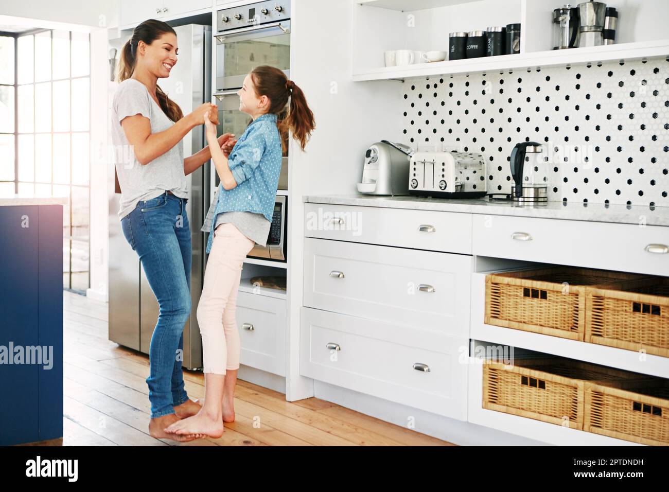 Moving and grooving with Mom. a happy mother and daughter playfully dancing together at home