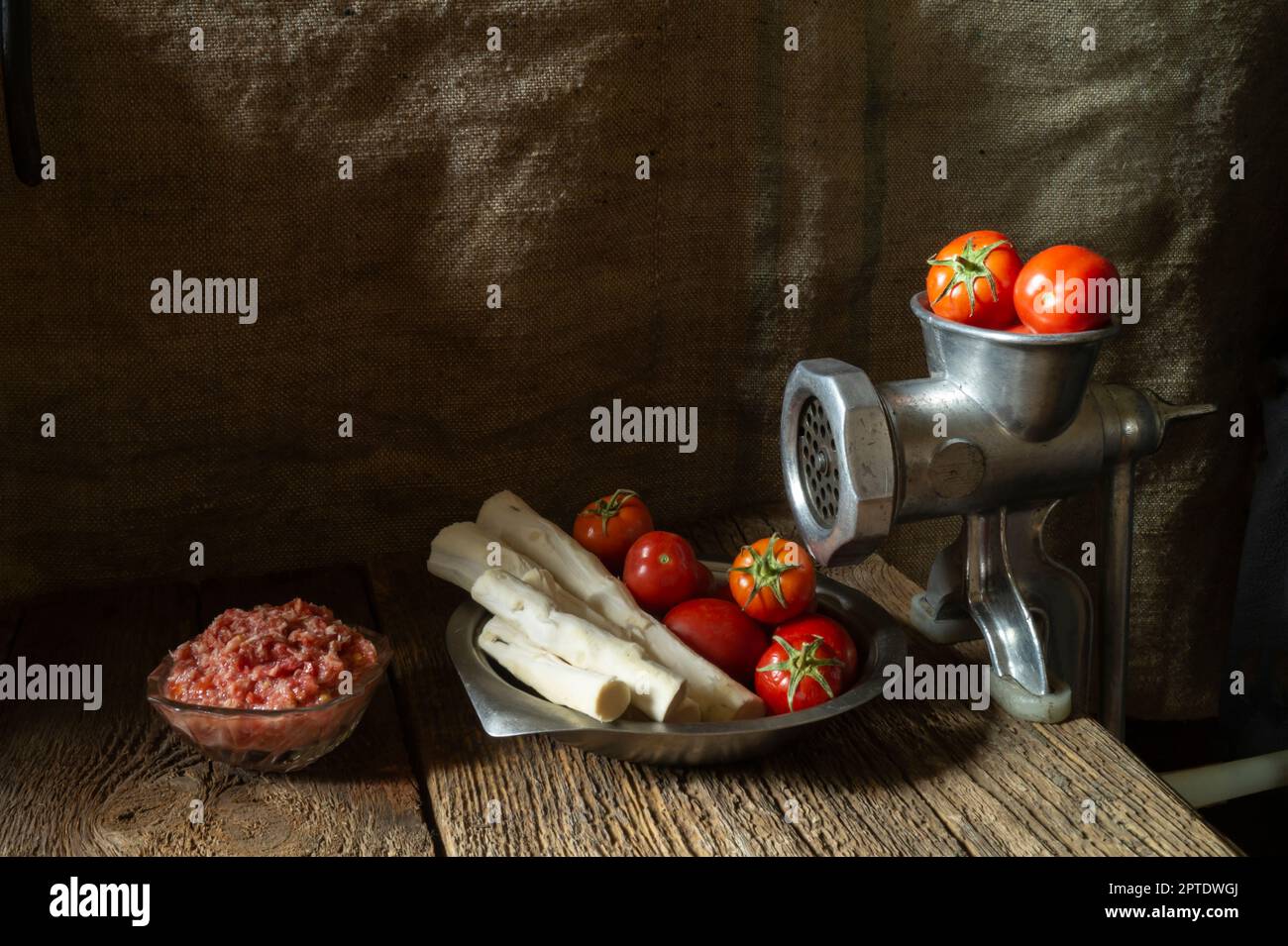 Ripe vegetables for cooking spicy seasoning. Tomatoes and horseradish root with garlic on a dark background Stock Photo