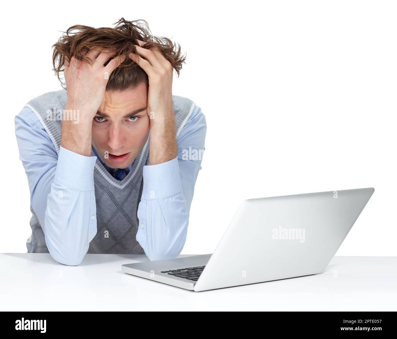 Why did I buy a cheap laptop. A frustrated man with his head in his hands next to a cheap, broken laptop Stock Photo