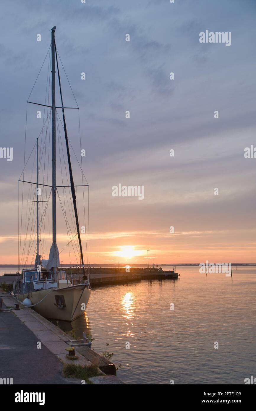 Sailing ship in the harbor of lake Vaettern at sunset. Lighthouse in ...