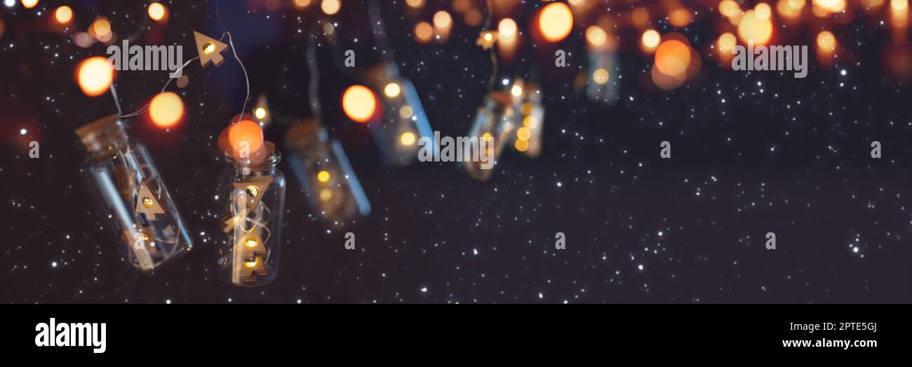 Garland of christmas lights on dark night sky. Illuminated string of