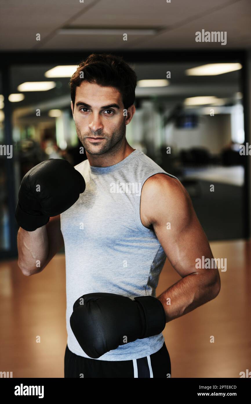 Stern stance. Portrait of a focused man wearing boxing gloves and sport