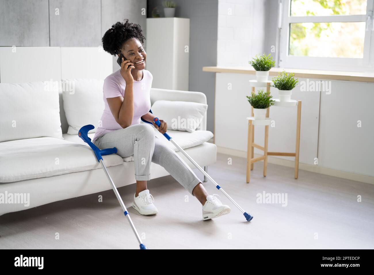 Woman With Leg Injury Using Crutches At Home Stock Photo Alamy