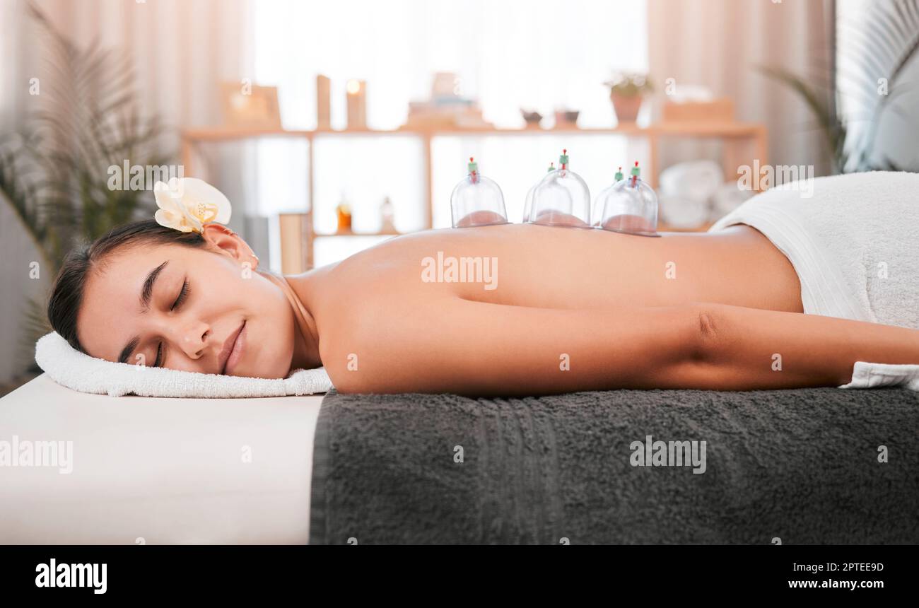 Cupping therapy, spa and relax woman in massage, zen or luxury room for holistic muscle wellness. Calm, healing and peace client with glass cup for ph Stock Photo