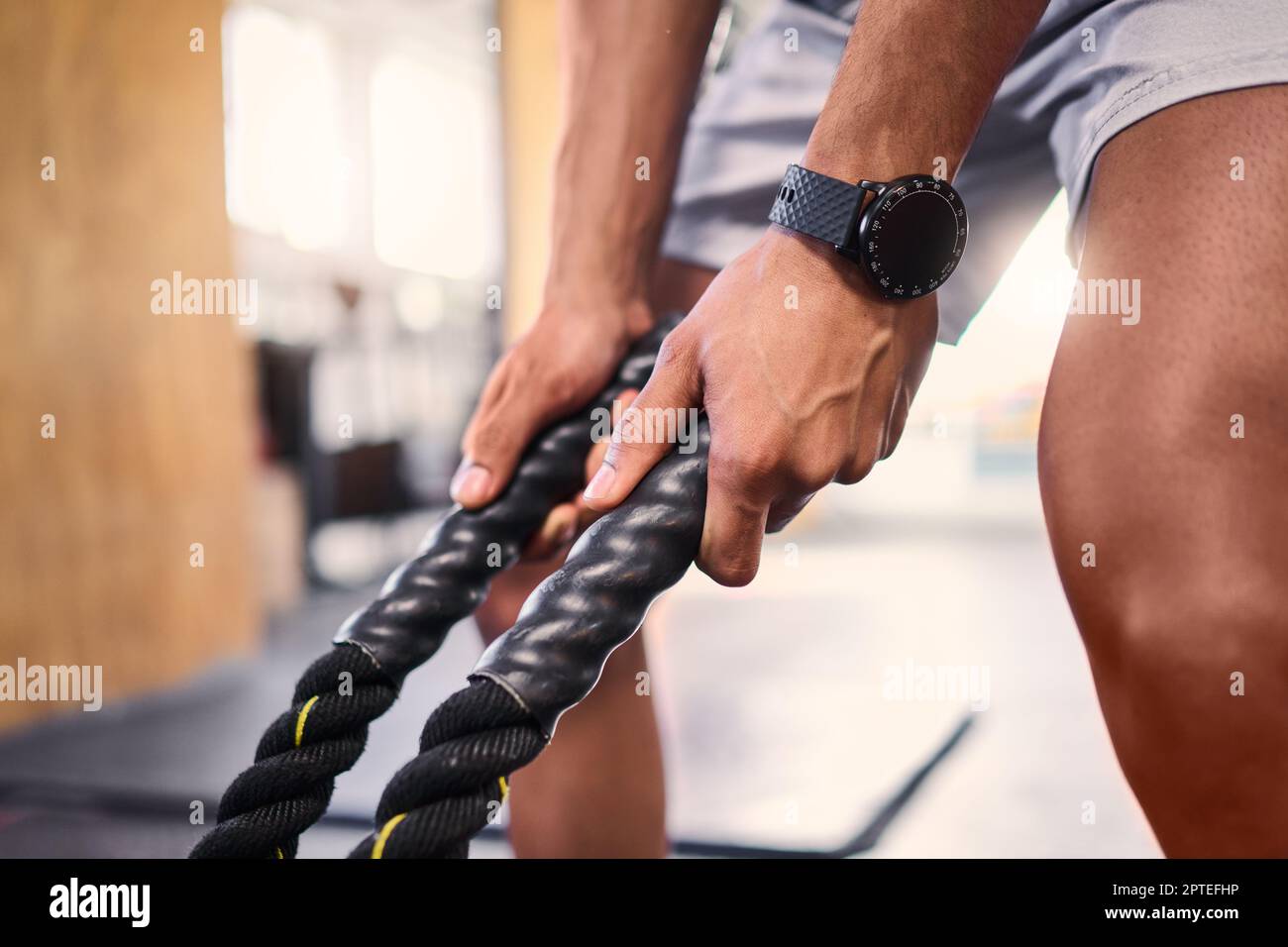 Hands, fitness and battle rope with a sports man training for cardio or