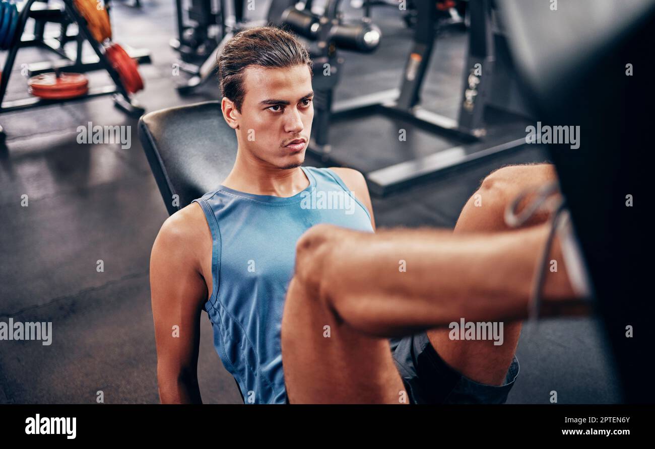 Fitness, gym and man on leg press machine training legs and thigh