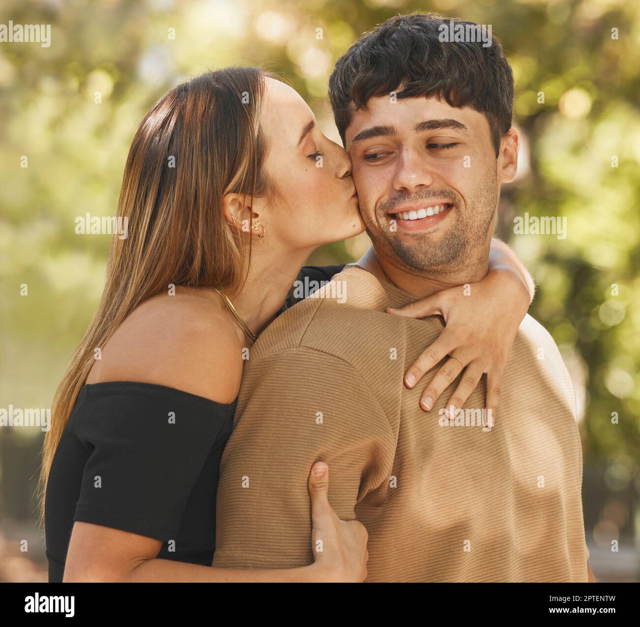 Happy couple, love and kiss on cheek outdoor in nature park for ...