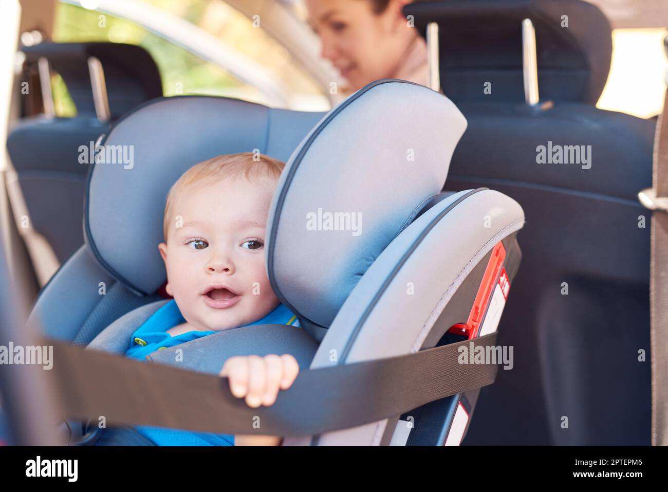Lets go, Mom. a mother sitting in a car with her baby boy in a car seat