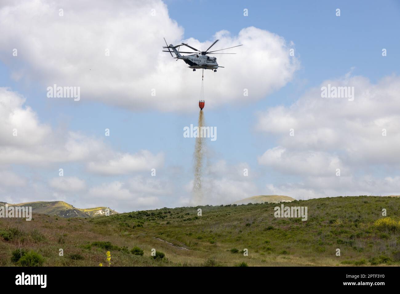 A U.S. Marine CH-53E Super Stallion helicopter drops water from a bambi bucket over a target area during the annual Cory Iverson Wildland Firefighting exercise at the Las Pulgas Lake on Marine Corps Base Camp Pendleton, California, April 19, 2023. The Cory Iverson Wildland Firefighting exercise is an annual event that focuses on interagency cooperation between the California Department of Forestry and Fire Protection, San Diego County Sheriff's Department, and the Department of Defense. During the exercise, each entity works together to create an effective, efficient, and well trained team to Stock Photo