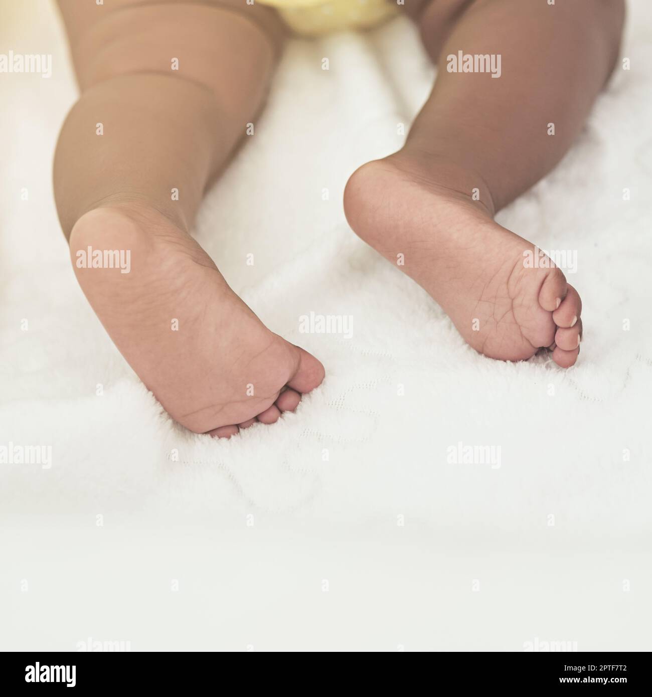 These feet will leave big foot prints one day. a baby girl asleep on a