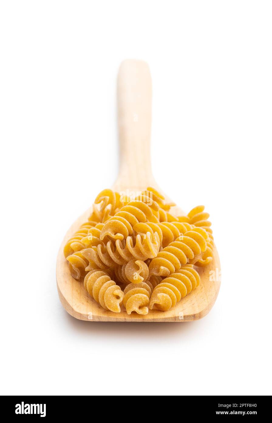 Uncooked whole grain pasta isolated on white background. Raw pasta on the spoon. Stock Photo