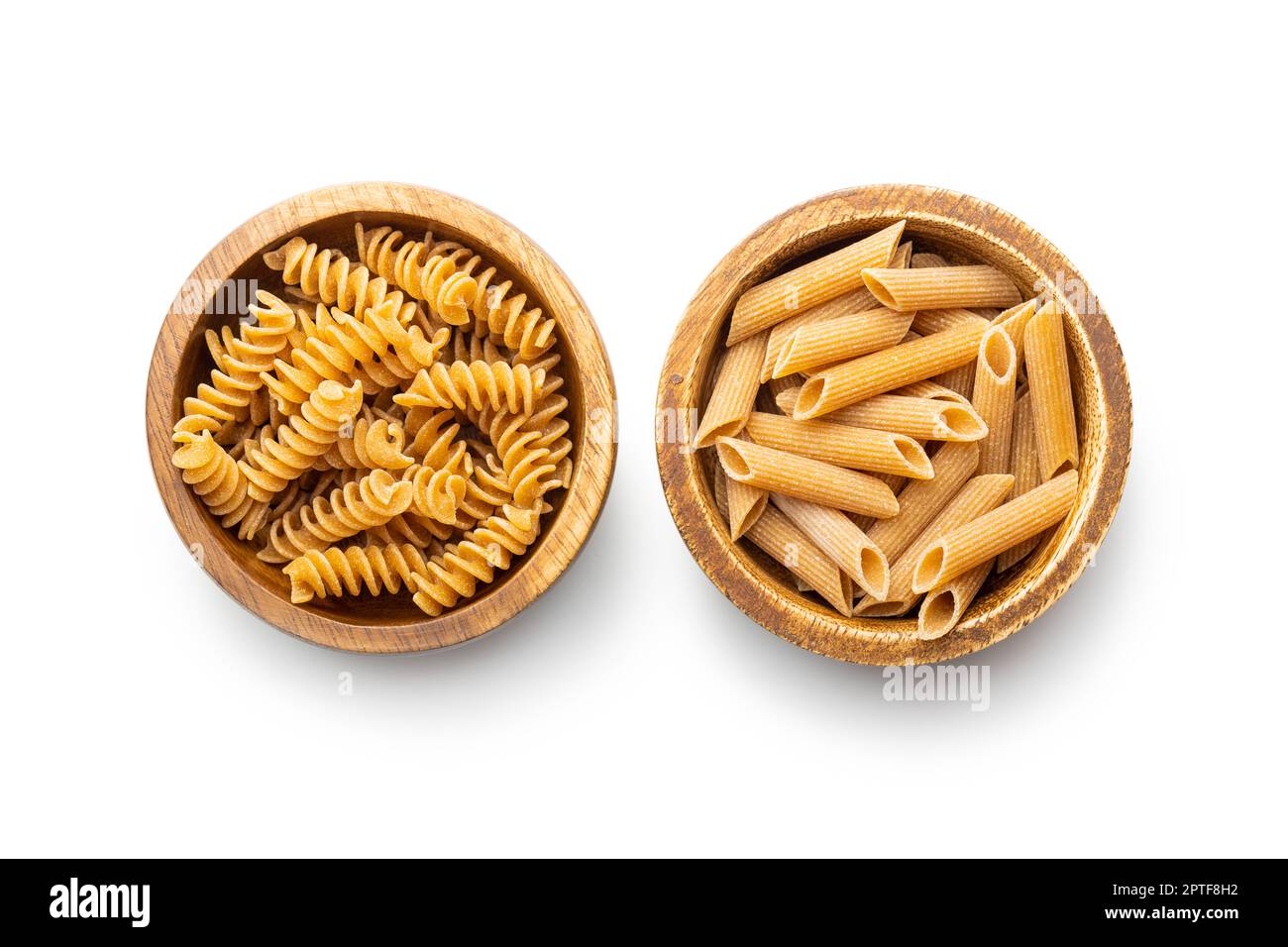 Uncooked whole grain pasta isolated on white background. Raw pasta in the bowl. Stock Photo
