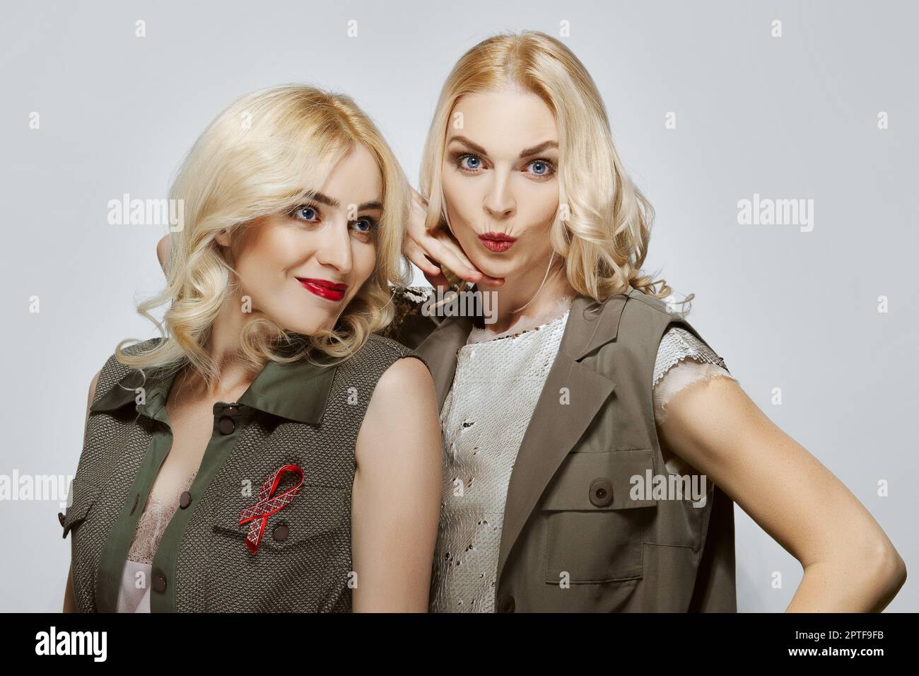 Two happy and joyfull attractive blonde girls . Natural makeup, red lips and blue eyes. Stock Photo