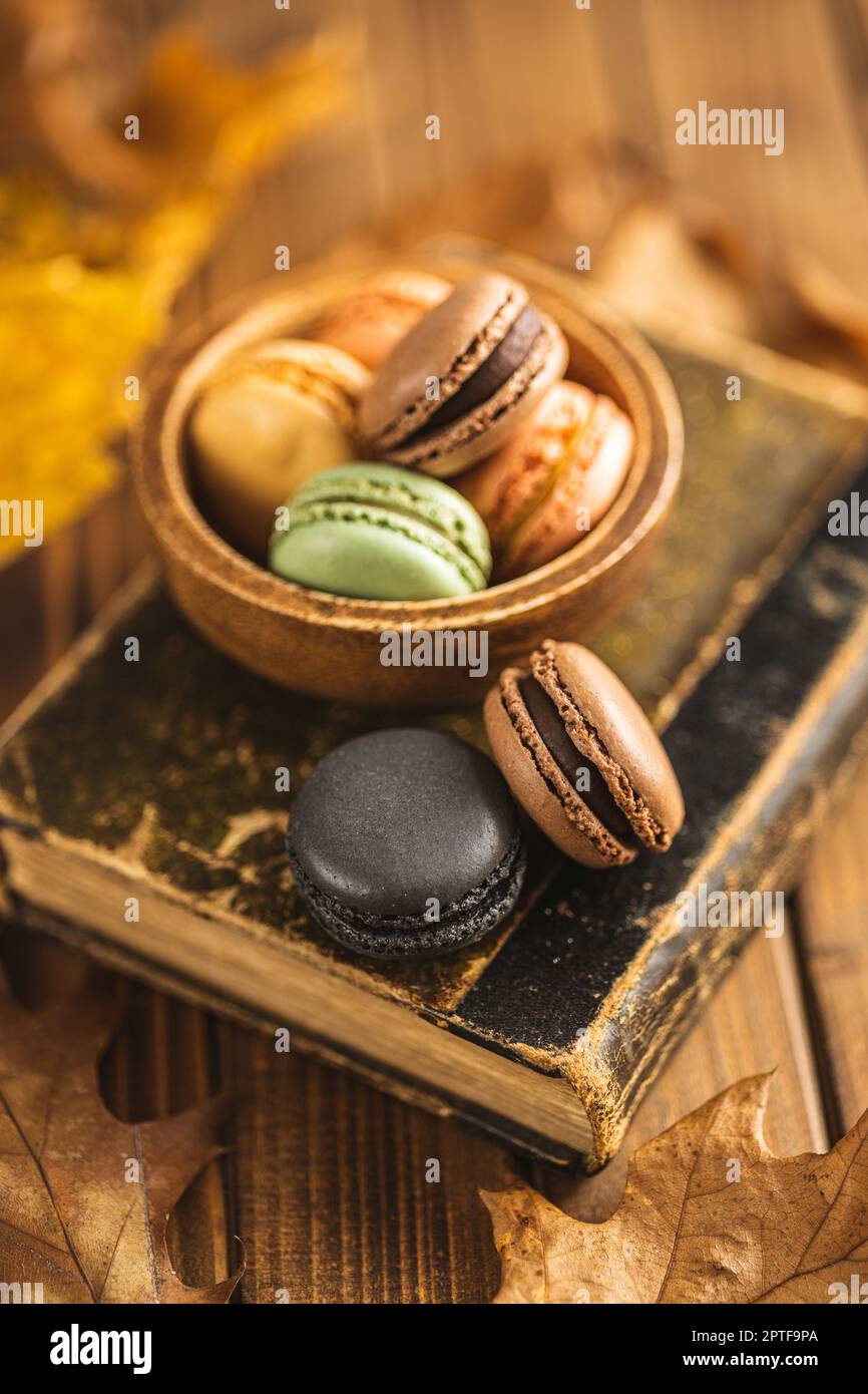 Sweet macaron dessert. Colorful macarons on the old book. Stock Photo
