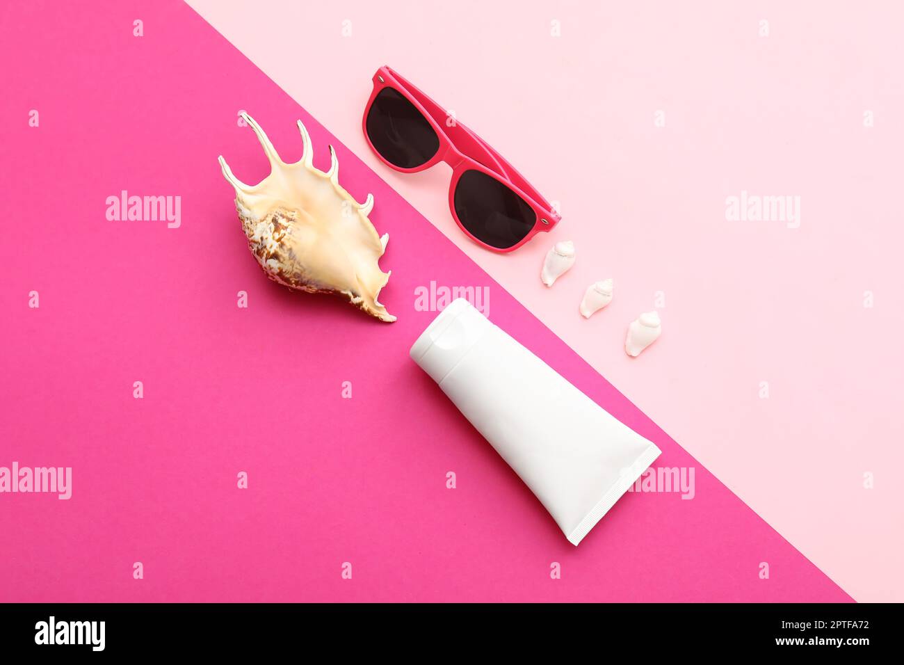Composition with sunglasses, seashells and sunscreen on pink background Stock Photo