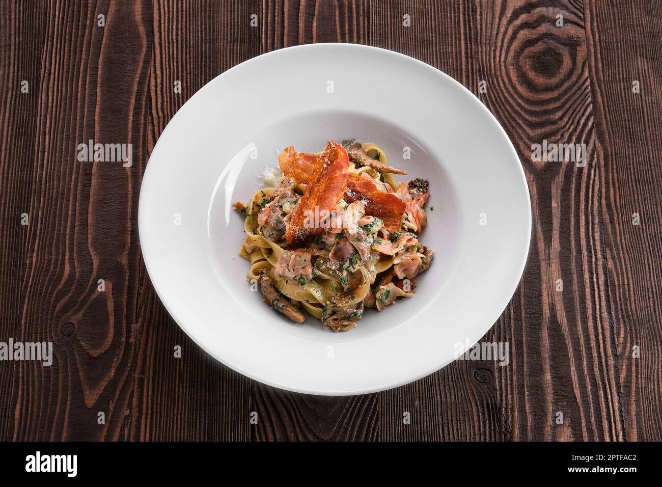 Pasta with chicken, oyster mushrooms and bacon chips Stock Photo - Alamy