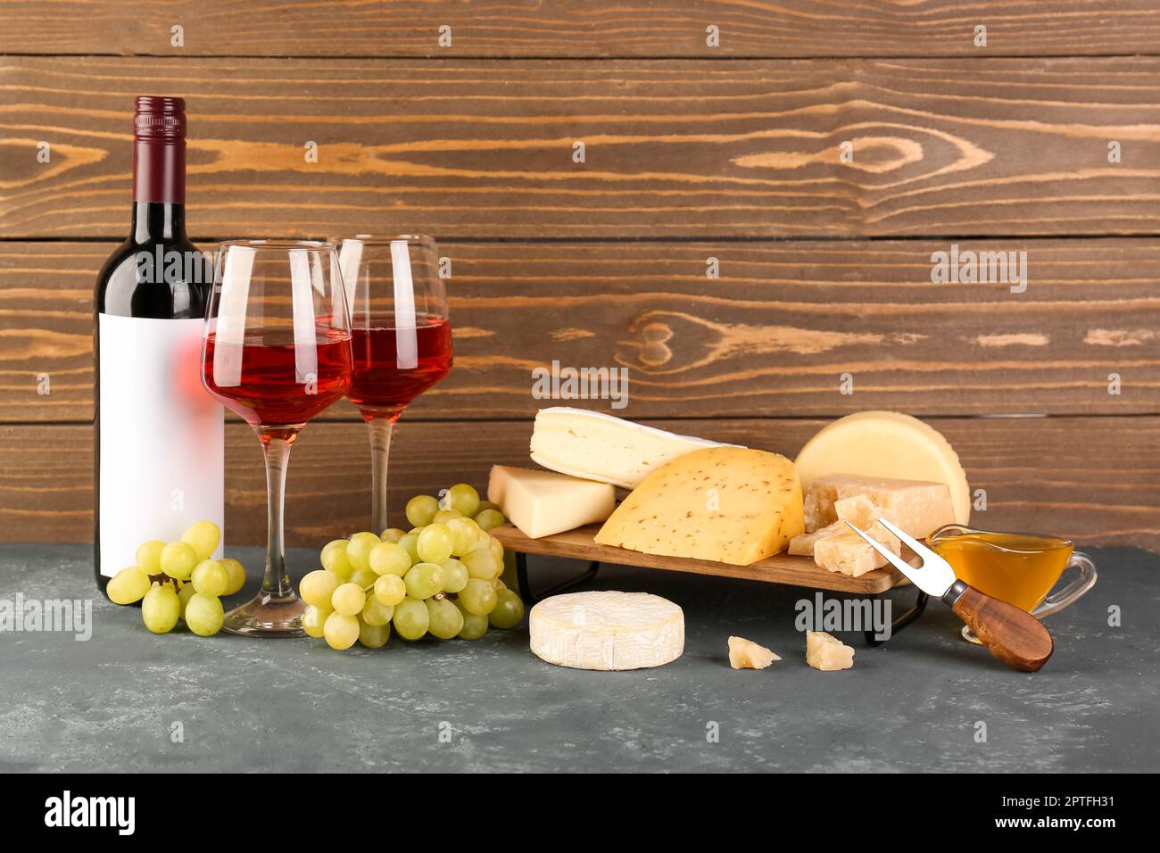 Different types of cheese, bottle and glasses with wine on table Stock ...