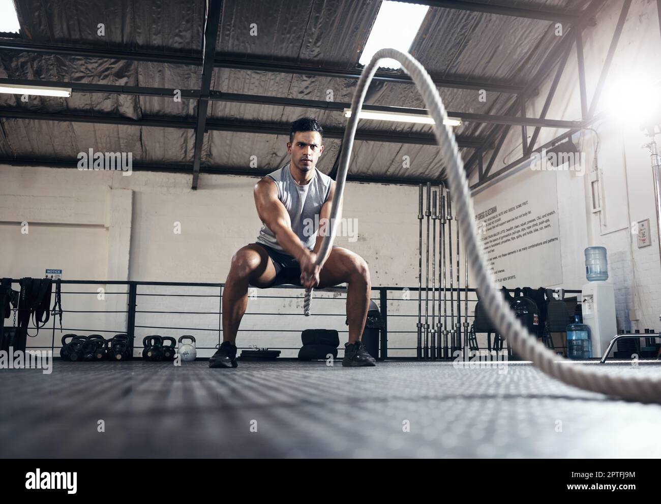 Man workout and fitness with rope at gym for health exercise and