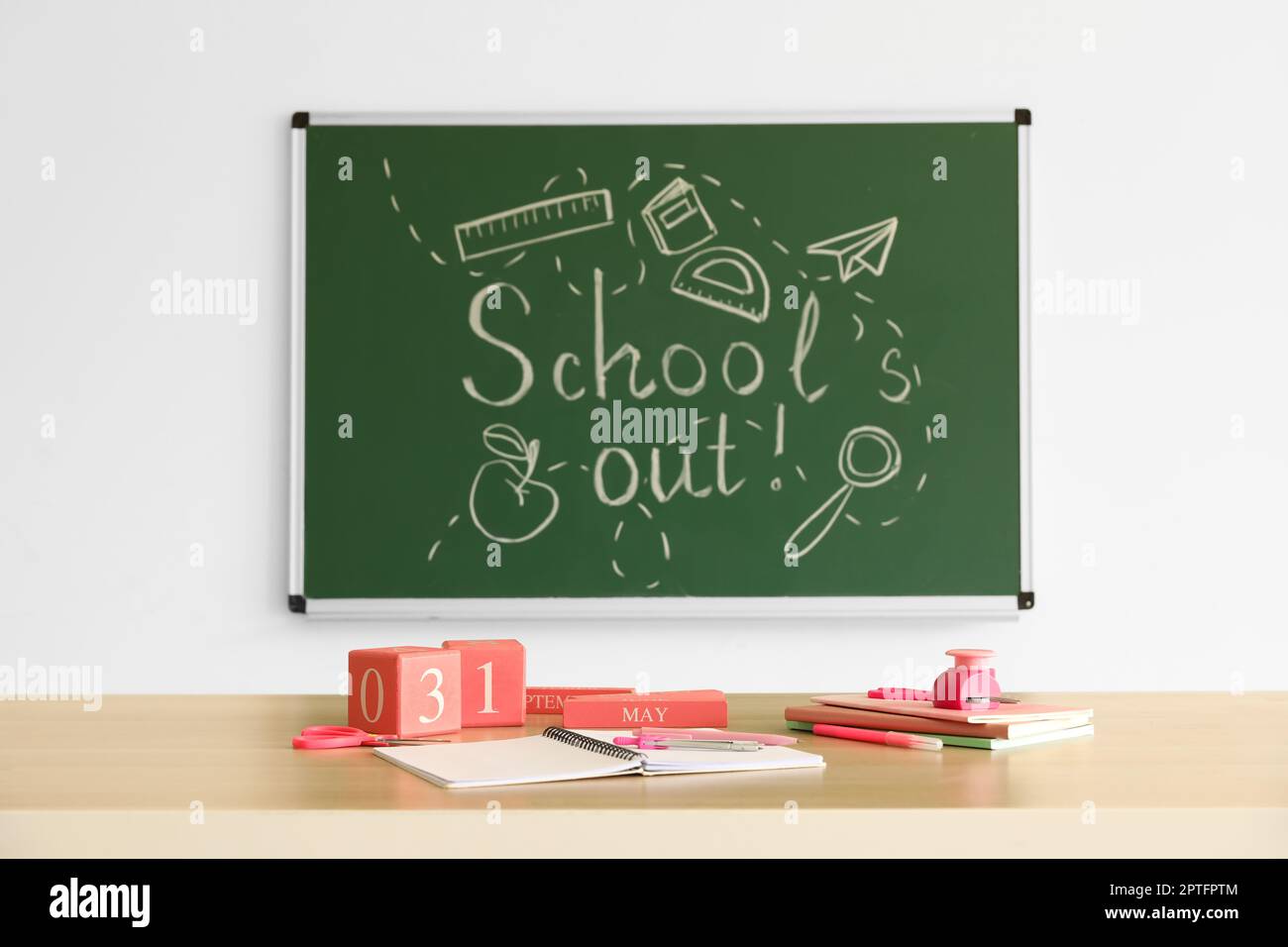 Blackboard with text SCHOOL'S OUT, drawings and desk in classroom Stock Photo Alamy