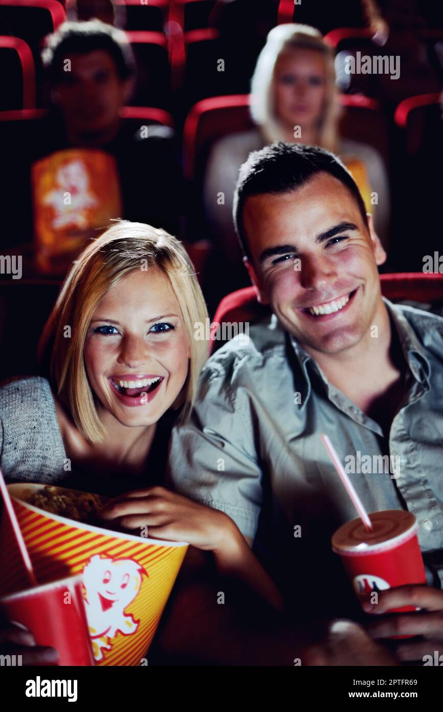Date night at the movies. Portrait of a happy couple sharing popcorn in