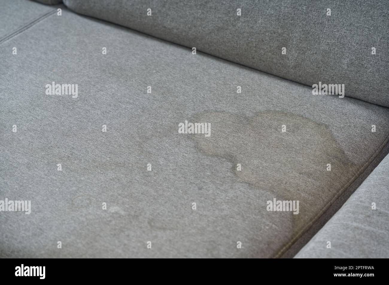 Dirty, stain, blot, fleck of water on the fabric, textile sofa. Dirty textile sofa chemical