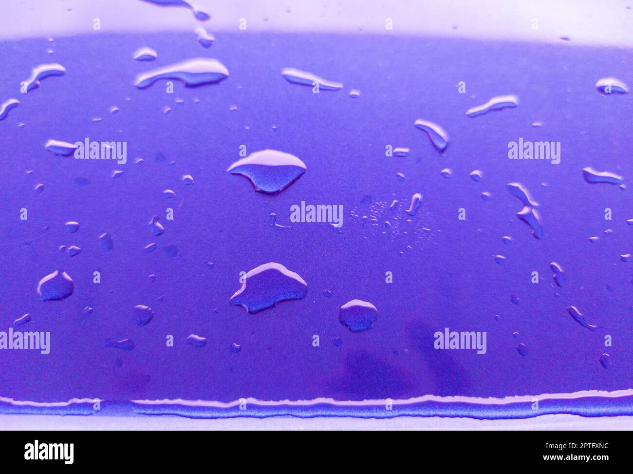 Landscape of drops on the car body after washing it with a pressure gun. Purple color Stock Photo