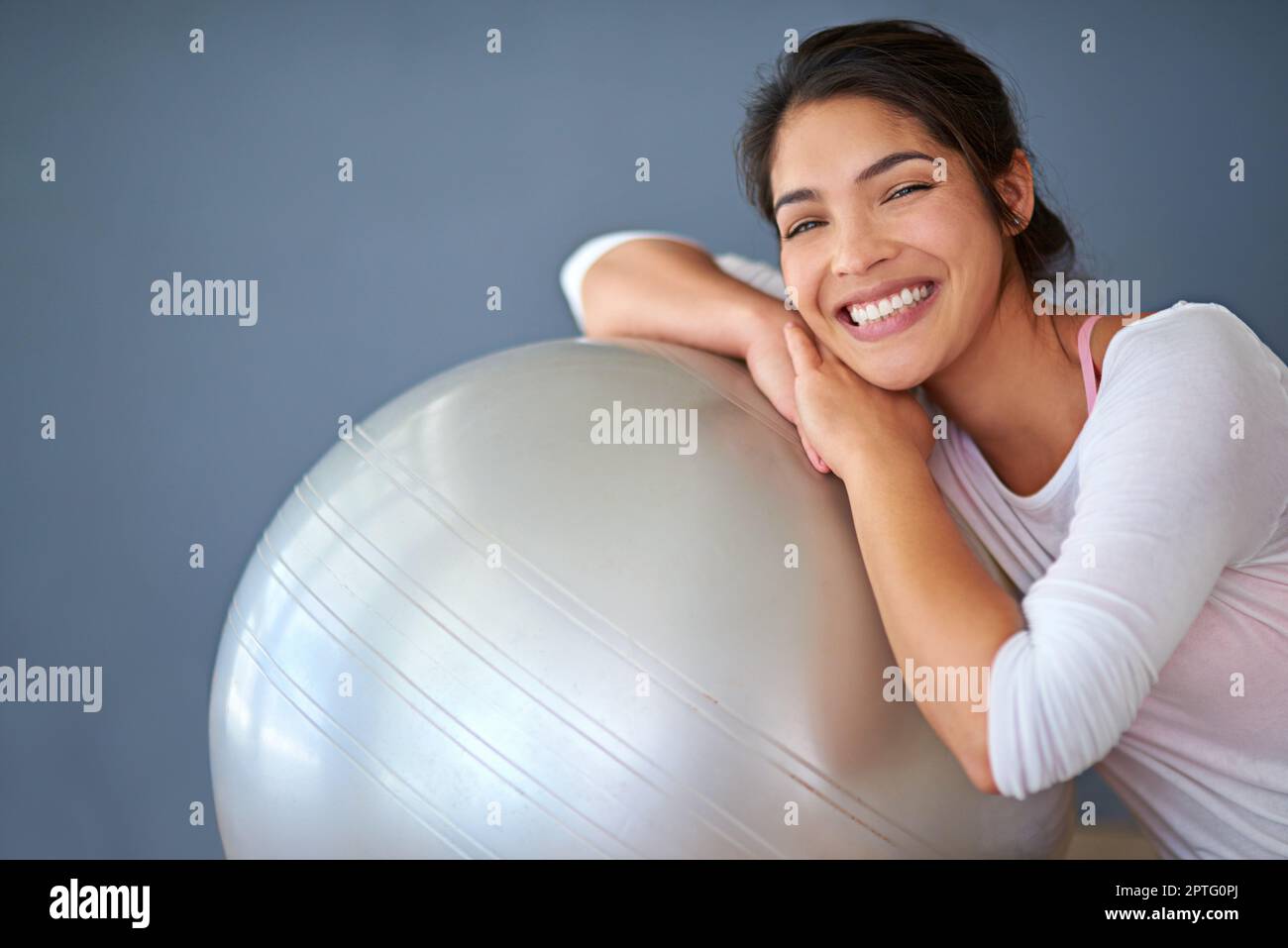 https://c8.alamy.com/comp/2PTG0PJ/this-is-a-must-have-for-every-home-gym-a-sporty-young-woman-leaning-on-a-pilates-ball-against-a-grey-background-2PTG0PJ.jpg