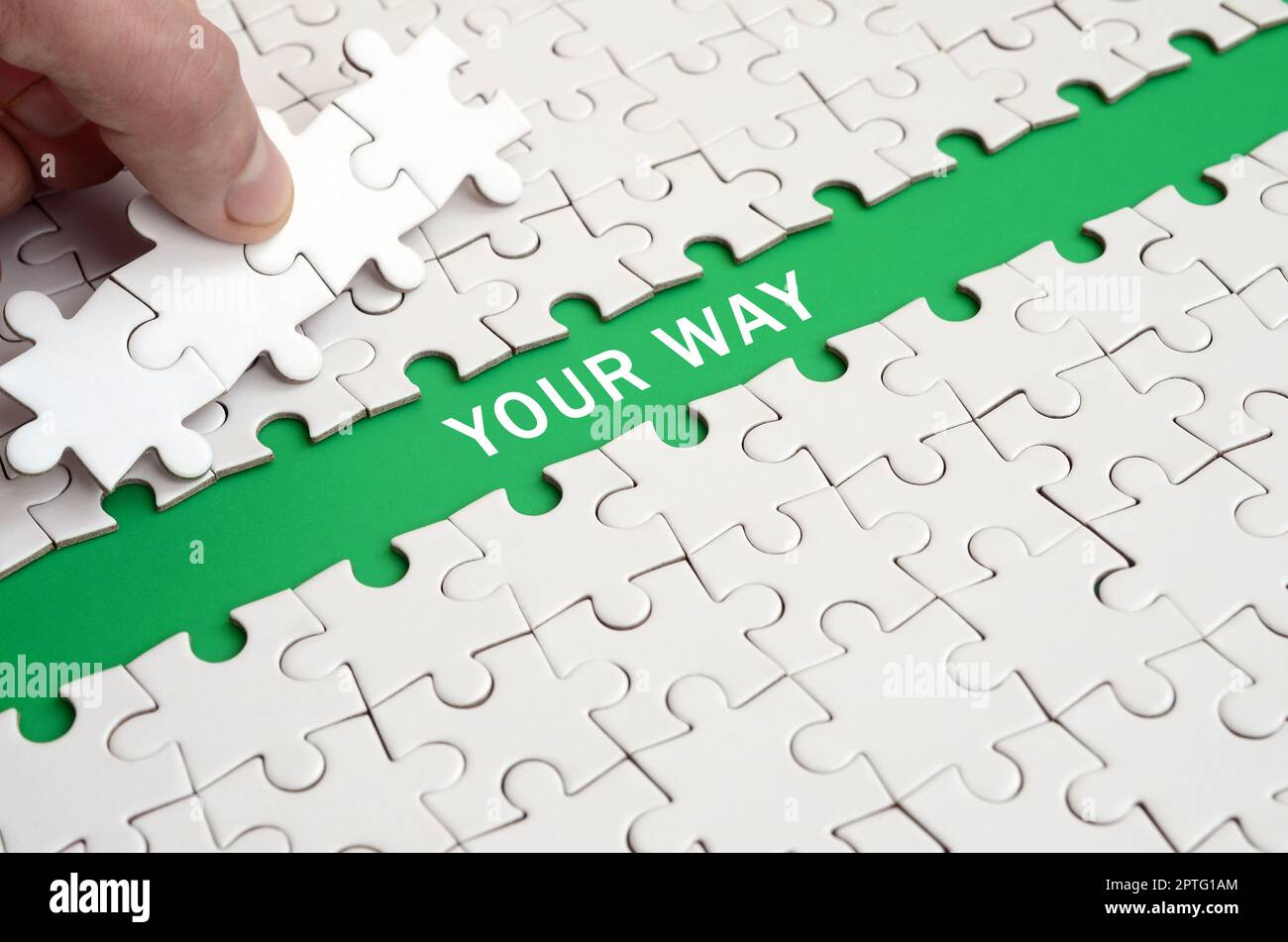 The human hand paves the way to the surface of the jigsaw puzzle The human hand paves the way to the surface of the jigsaw puzzle