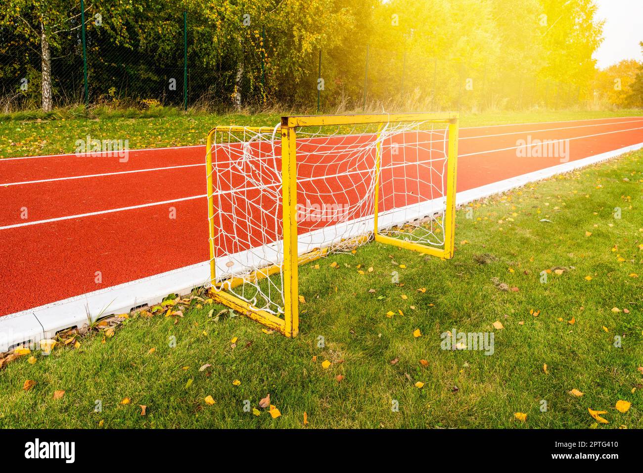 Small football goals next a running track in a stadium during autumn