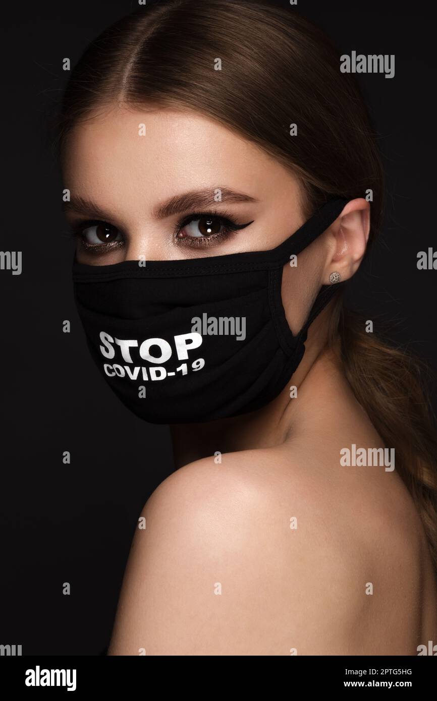 Portrait of a beautiful woman in a black mask stop covid and classic ...
