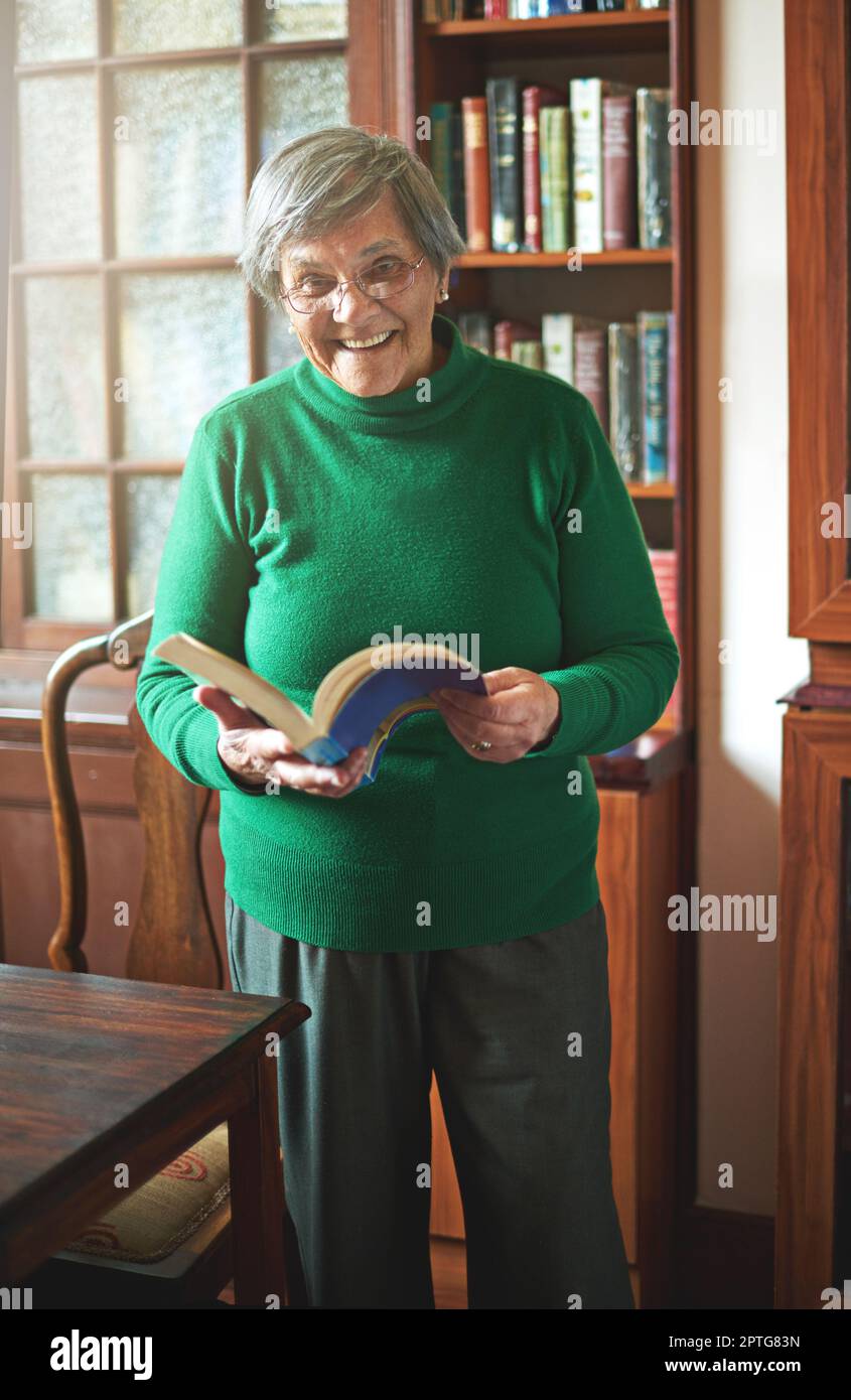 Reading keeps my mind sharp. Portrait of a smiling senior woman reading ...