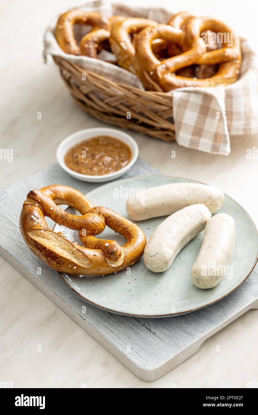 Traditional Bavarian white sausages on the plate and pretzes. Stock Photo